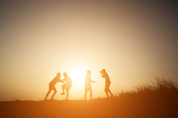 Fototapeta na wymiar Silhouette Children playing on summer sunset happy time