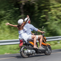 Fototapeta na wymiar Cheerful couple riding scooter