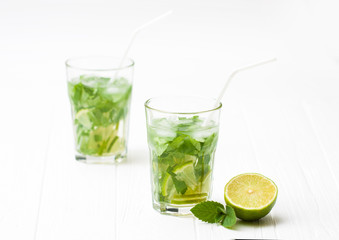 Mohito mojito drink with ice mint and lime on wooden white table