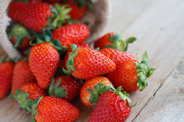 strawberries in small sack on wooden table background