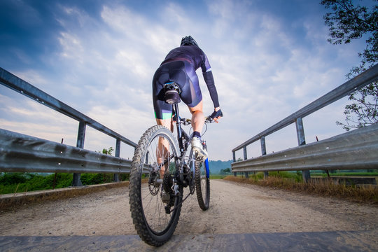 Man riding on a dirty road on a mountain bike 