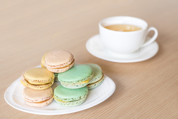  French colorful macaroons sweet dessert and with a cup of tea.