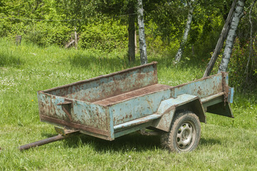 Obsolete weathered metal lightweight cargo trailer platform in farmyard