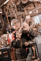 Wood turners using a rotating clamp to turn the wood.