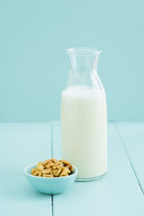 Fresh homemade walnut milk in a bottle with fresh walnuts