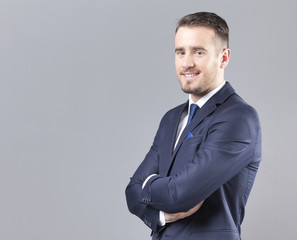Portrait of a happy smiling businessman on grey background