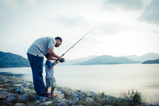 son and dad fishing at dam,vintage tone