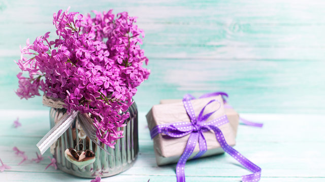 Aromatic  lilac flowers in vase and boxes with gifts on turquois