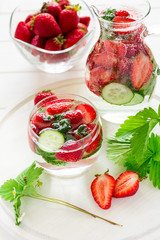 Detox. Fresh lemonade with strawberries, cucumber and mint on white wooden table