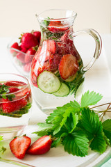 Detox. Fresh lemonade with strawberries, cucumber and mint on white wooden table