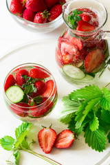 Detox. Fresh lemonade with strawberries, cucumber and mint on white wooden table