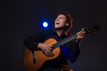 Obraz na płótnie Canvas Cheerful man playing on guitar