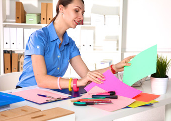 Young graphic designer working on laptop using tablet at home