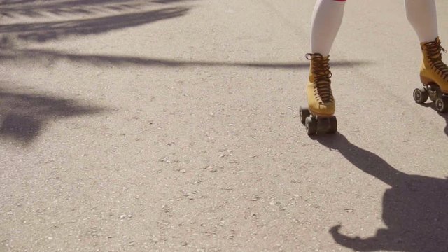 Close-up of female legs in white stockings on vintage roller skater. It's also nice to see a silhouette and a road marking.