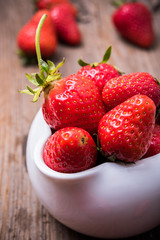 red organic strawberries in white bowl 