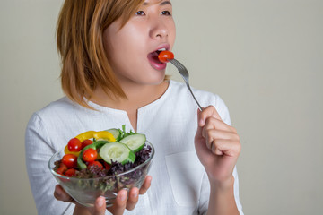 beautiful woman standing holding bowl of salad eating some veget