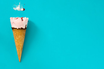 Strawberry ice cream cone on blue background
