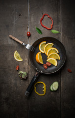 Fresh salad with slice of orange on a wooden background