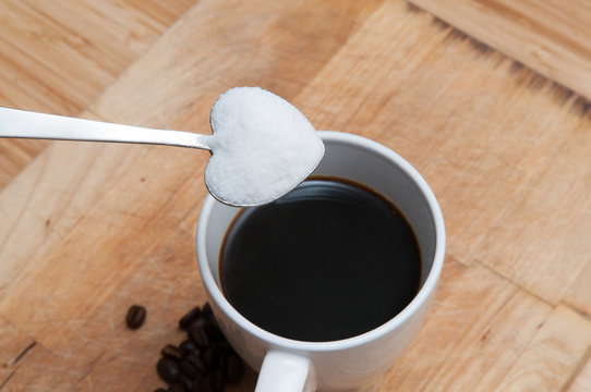 Coffee cup with sugar on a heart shaped spoon