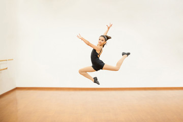 Fototapeta premium Girl practicing some jumps in dance class