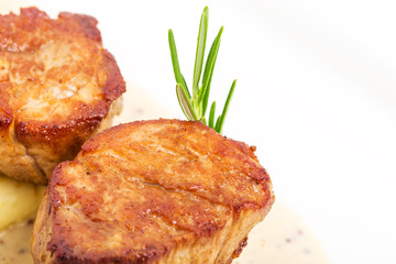 Fried pork tenderloin medallions on mustard sauce.