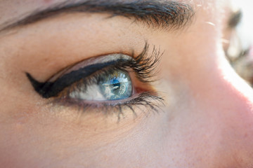 Fototapeta na wymiar Close-up of young woman's blue eyes with long eyelashes