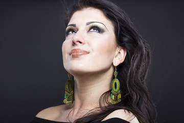 Beautiful brunette with a flying hair. Portrait of a beautiful girl in the jewelry. Shiny hair. Fashion. Ornaments on the beautiful woman
