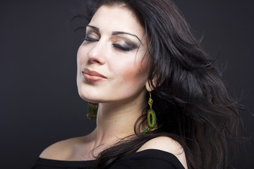 Naklejka premium Beautiful brunette with a flying hair. Portrait of a beautiful girl in the jewelry. Shiny hair. Fashion. Ornaments on the beautiful woman 