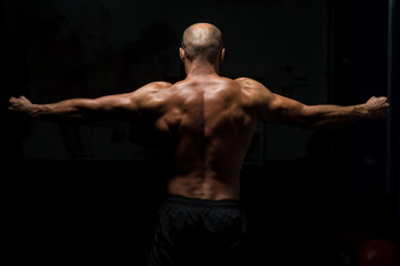 Obraz na płótnie Canvas Back View OF A Muscular Man Praying