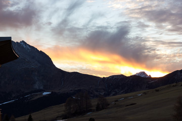 Naklejka na ściany i meble Mountain views of Alpe di Siusi with red sunrise
