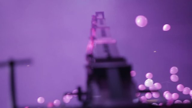Engineer moving crane with camera.Crane in action at night concert. Crane moving over crowd of people through spotlight and white balloons. Tracking shot.  