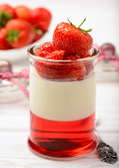 Milk dessert - panna cotta with strawberry jelly and strawberries.