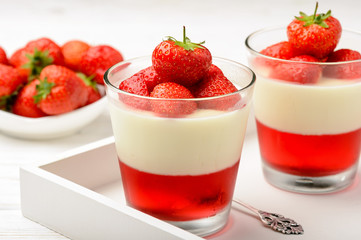 Milk dessert - panna cotta with strawberry jelly and strawberries.