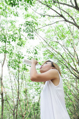 Portrait of young beautiful  woman wearing white dress drinking