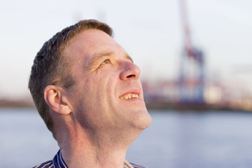 Obraz premium Mann als Fischer am Strand mit Hafen und Copyspace