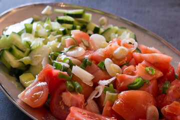 Mixed tomato salad with green onion, chive, cucumber and olive oil