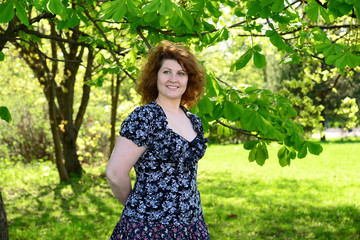 Fototapeta na wymiar woman standing in park near the chestnut