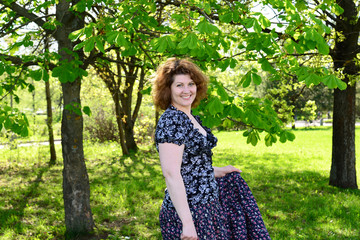 Fototapeta na wymiar woman in skirt standing in park near the chestnut