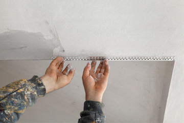 Worker install batten at ceiling and wall