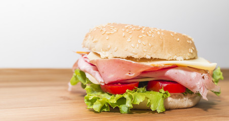 Panino con mortadella,formaggio, pomodoro e insalata su tagliere di legno