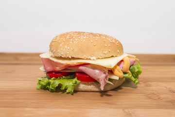 Panino con mortadella,formaggio, pomodoro e insalata su tagliere di legno