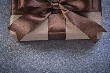 Packed present in brown shop paper on grey background front view