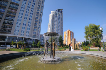 Fototapeta premium Bride and groom posing at the old fountain