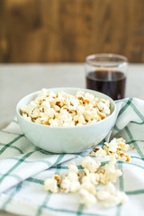 bowl of salty popcorn and soda