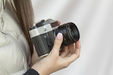 the girl with the French manicure is holding the vintage  camera