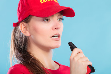 Lifeguard woman blowing whistle.