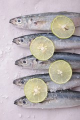 sardines with lime wedges and sea salt on tracing paper