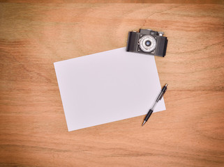 Vintage camera, pen and blank paper