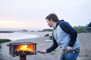 Man making grill near ocean