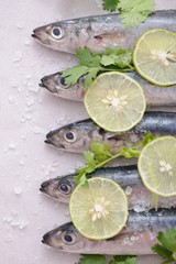 Close up sardines with lemon wedges and parsley on white plate 